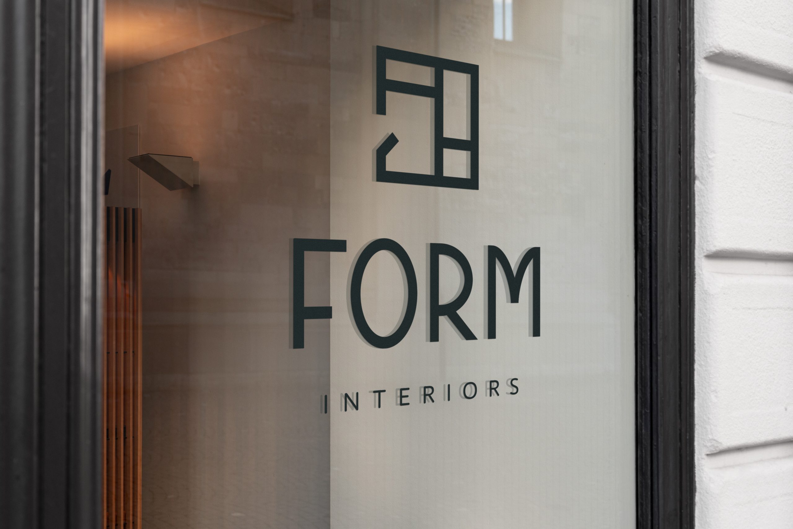 Form Interiors window appliqué and signage mockup on a window. Features the main logo lockup for Form Interiors.